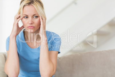 Worried young woman sitting in the living room