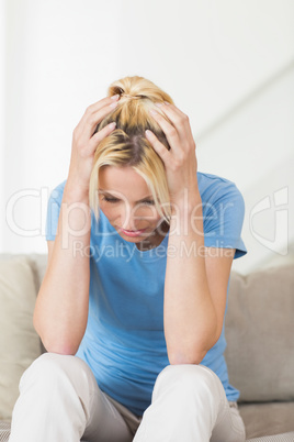 Worried young woman sitting in living room