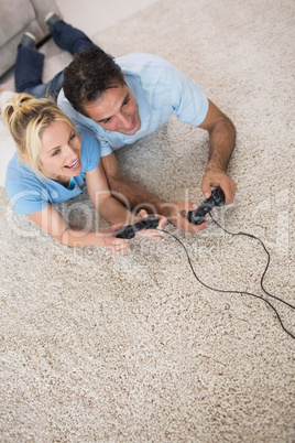 Couple playing video games on area rug