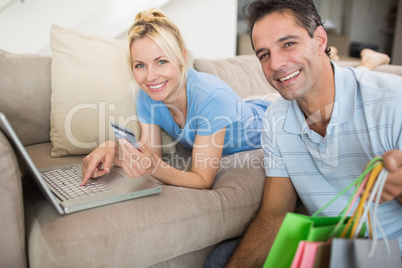 Portrait of smiling couple doing online shopping at home