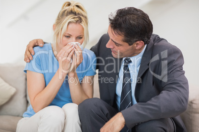 Well dresses man consoling a woman in living room