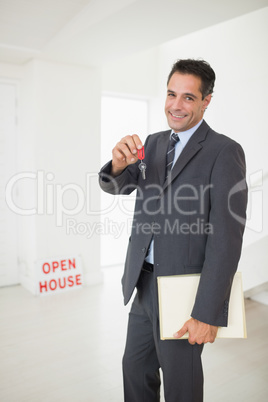 Businessman with documents holding up keys