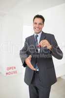 Businessman offering a handshake while holding up keys
