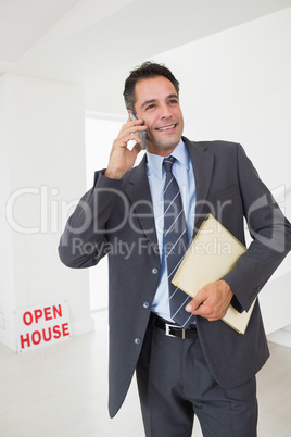 Real estate agent with documents using mobile phone