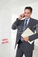 Real estate agent with documents using mobile phone