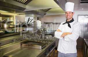 Smiling male cook with arms crossed in the kitchen