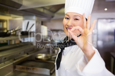 Portrait of a smiling female cook gesturing okay sign