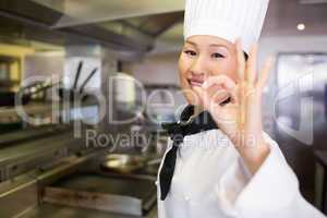 Portrait of a smiling female cook gesturing okay sign