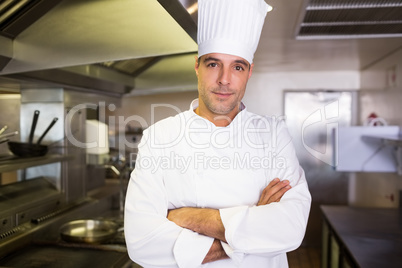 Male cook with arms crossed standing in kitchen