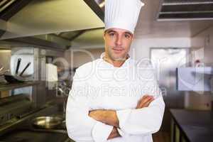 Male cook with arms crossed standing in kitchen