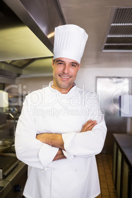 Smiling male cook with arms crossed in the kitchen