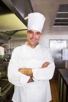 Smiling male cook with arms crossed in the kitchen