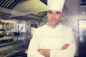 Smiling male cook with arms crossed in kitchen