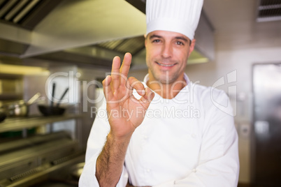 Male cook gesturing okay sign in kitchen