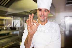 Male cook gesturing okay sign in kitchen