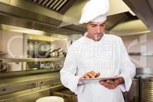 Male cook using digital tablet in kitchen