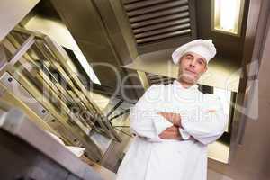 Smiling male cook with arms crossed in kitchen