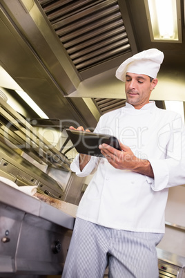 Male cook using digital tablet in kitchen