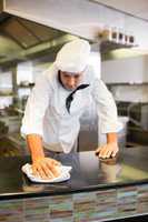 Male cook wiping kitchen counter