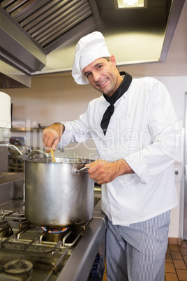 Smiling male chef preparing food in kitchen