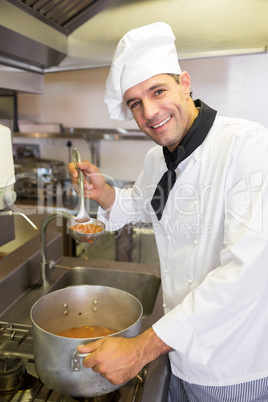 Smiling male chef preparing food in kitchen