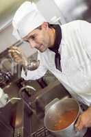 Male cook tasting food in the kitchen