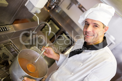 Smiling male chef preparing food in kitchen