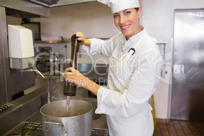 Smiling female cook preparing food in kitchen