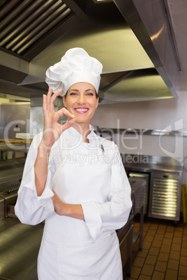 Female cook gesturing okay sign in kitchen