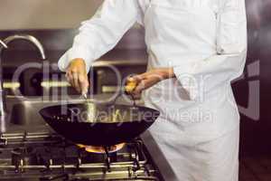 Mid section of a chef preparing food in kitchen