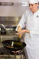 Concentrated female chef preparing food in kitchen