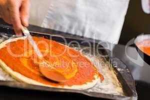 Mid section of a male chef preparing pizza