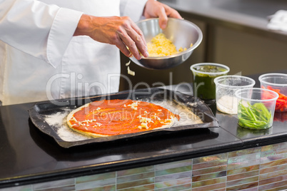 Mid section of a chef garnishing food in kitchen