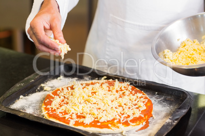 Mid section of a chef preparing pizza