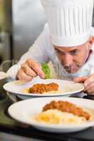 Male chef garnishing food in kitchen