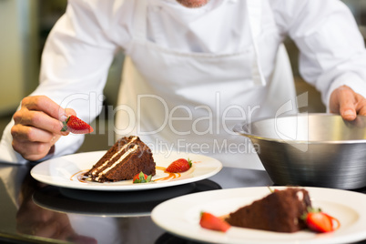 Mid section of pastry chef decorating dessert