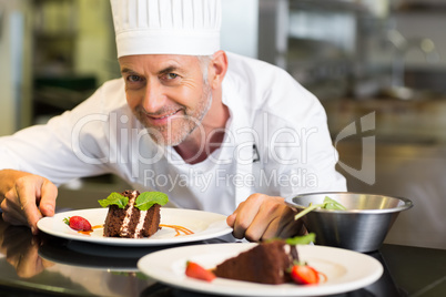 Smiling male pastry chef with dessert in kitchen