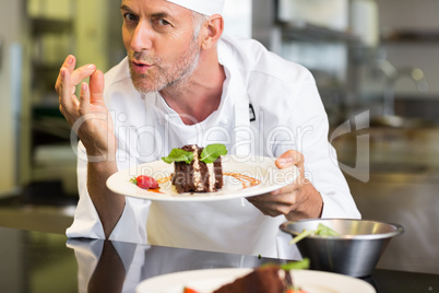 Smiling male pastry chef with dessert in kitchen