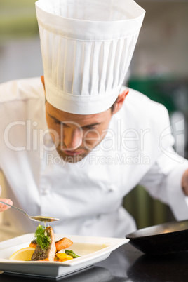 Closeup of a concentrated male chef garnishing food