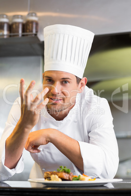 Smiling male chef with cooked food in kitchen