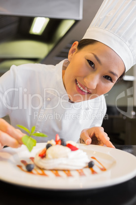 Closeup of a smiling chef garnishing food