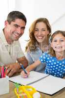 Parents assisting girl in drawing