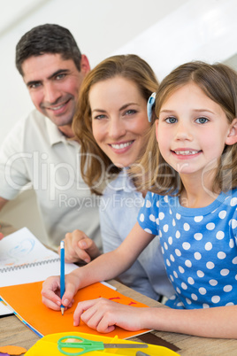 Girl drawing while sitting with parents