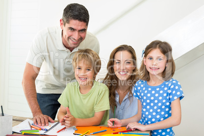 Smiling family coloring at home