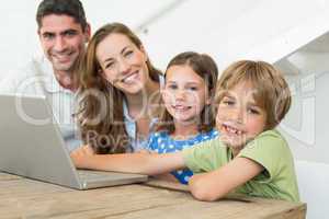 Smiling family using laptop