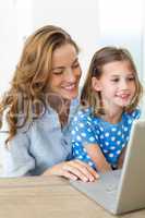 Mother and daughter using laptop