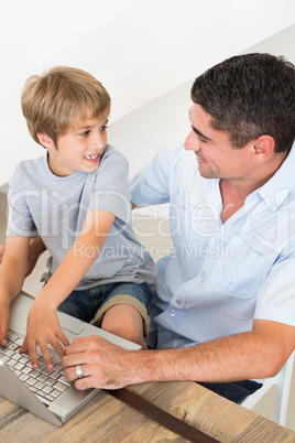 Boy and father using laptop