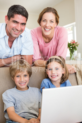 family with laptop in living room