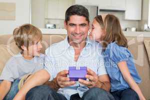 Father receiving gift from loving children