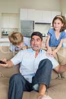 Children scaring father watching television